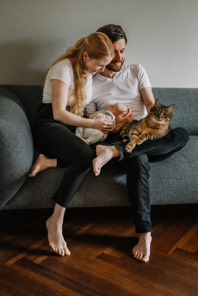 Babyfotos Bern - Paar mit Baby zuhause und Katze